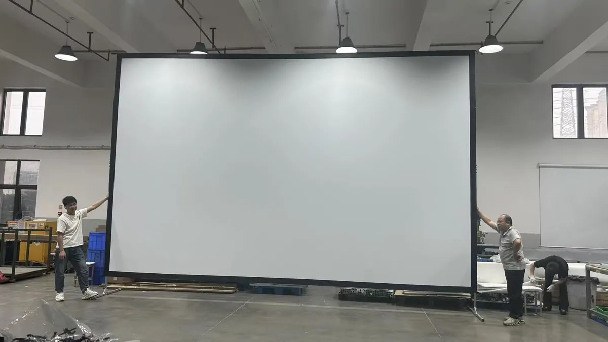 Staff handling a large deployed projection screen in the workshop