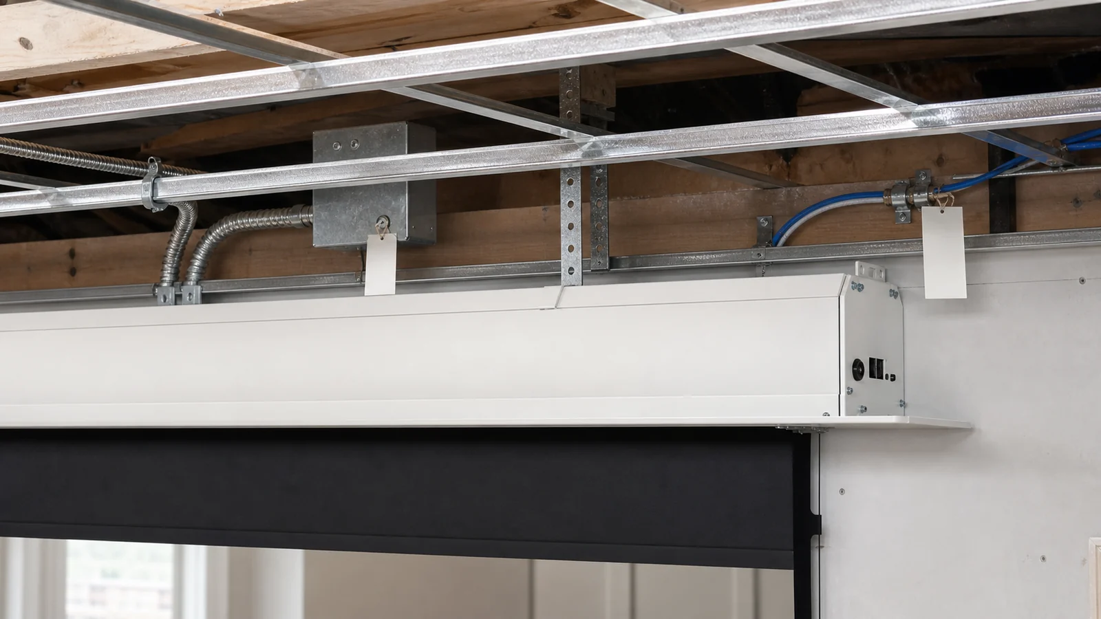 Motorized projection screen power and control cable routing reviewed before ceiling close-up